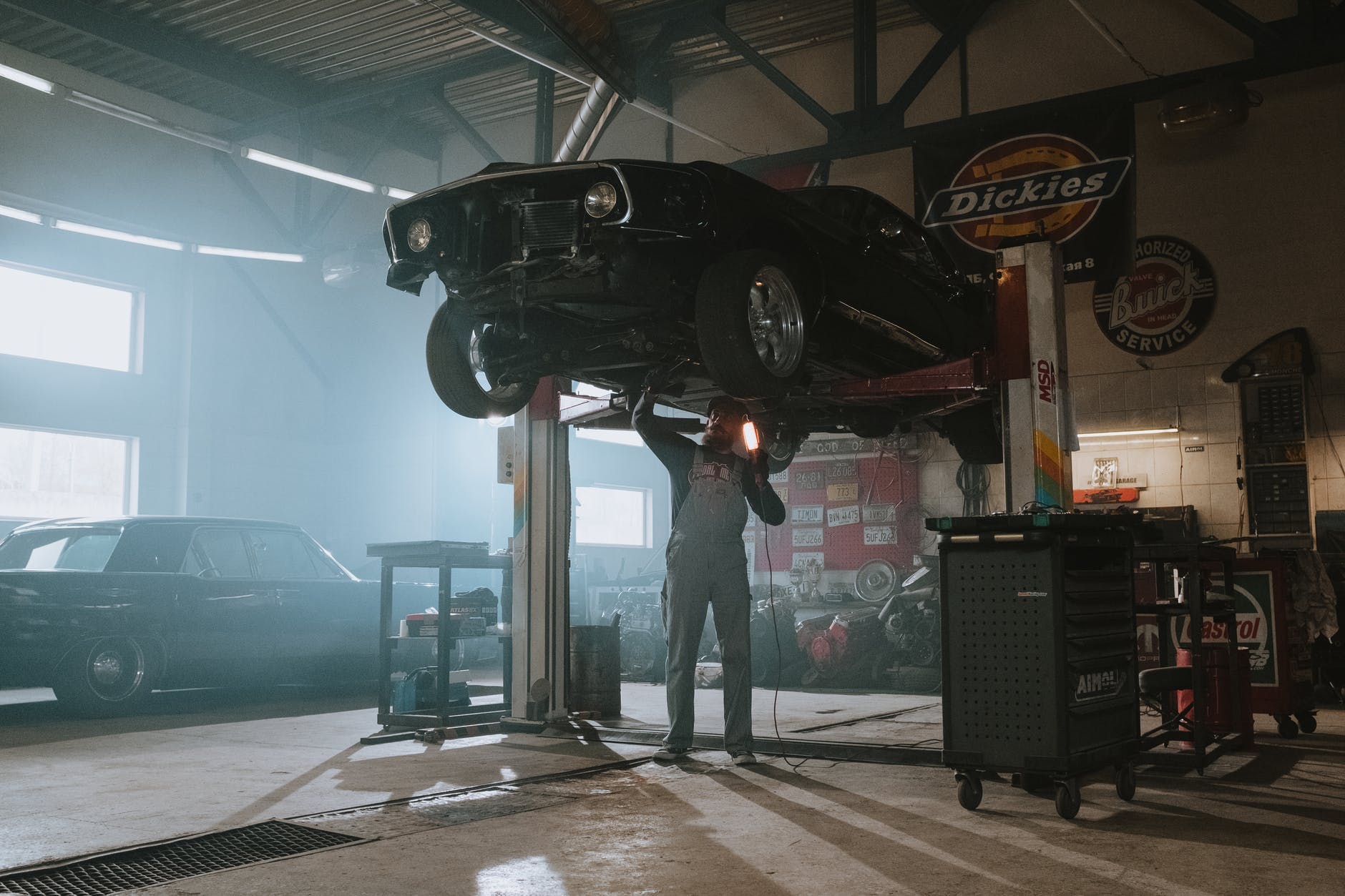 man in black jacket standing near black metal machine